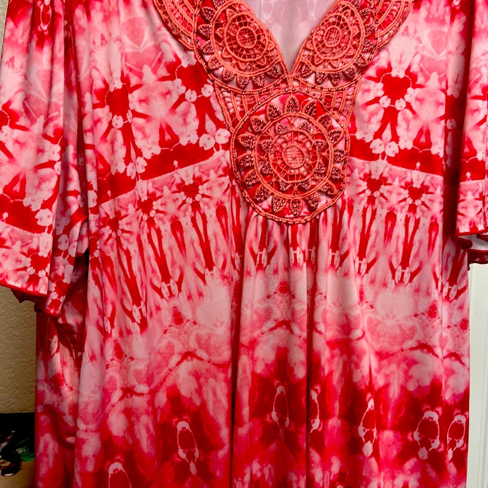 a red and white tie dye,  shirt, and polyester and spandex with an appliqué